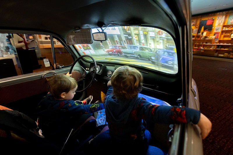 Two children inside car with projection