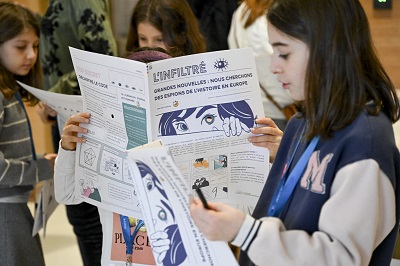 Young girl reading museum newspaper